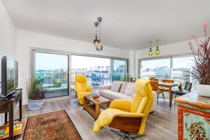 a living room with yellow chairs and a couch at Lisbon South Bay Seixal in Seixal