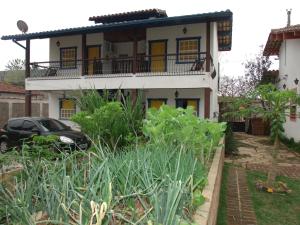 a house with a garden in front of it at Pousada Ora Pro Nobis in Catas Altas