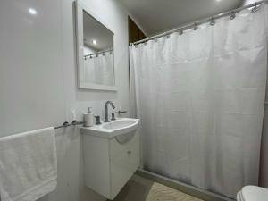 a white bathroom with a sink and a shower at Depto Estela - Monoambiente Zona Macrocentro para 2 PAX - Hola Sur in Mar del Plata +8 photos