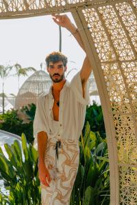 Un uomo è sotto un ombrello di Almar Resort Luxury LGBT Beach Front Experience a Puerto Vallarta
