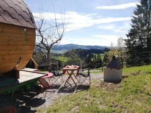 una mesa y sillas en un campo junto a un edificio en Auszeit-Wohnfass im Grünen 