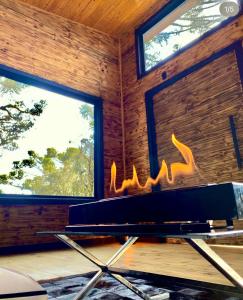 a fireplace in a room with two windows at Flor da serra in Urubici +112 photos