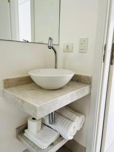 a bathroom with a sink and a mirror at Apartamento a 100 m da praia in Juquei