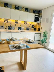 a kitchen with a wooden table with dishes on it at Apartamento a 100 m da praia in Juquei