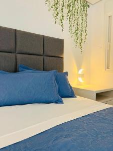 a bedroom with a large bed with blue pillows at Apartamento a 100 m da praia in Juquei