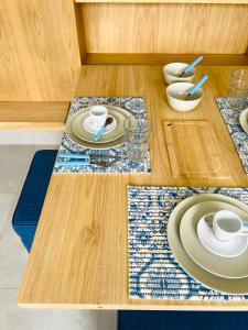 a wooden table with plates and cups on top of it at Apartamento a 100 m da praia in Juquei