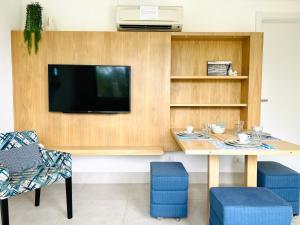 a living room with a table and a tv at Apartamento a 100 m da praia in Juquei