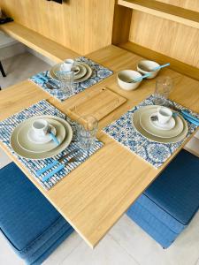 a wooden table with plates and dishes on it at Apartamento a 100 m da praia in Juquei