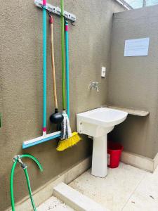 a bathroom with a sink and mop at Apartamento a 100 m da praia in Juquei