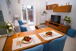 a living room with a table with two plates of food at Marant Luxury Apartment in Agios Rokkos