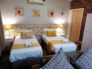 Habitación de hotel con 2 camas y sofá en Devine Stay- Pmb en Pietermaritzburg