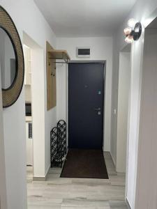 um corredor com uma porta preta e um espelho em Apartament D&T em Vatra Dornei