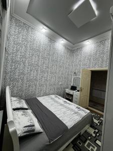 撒馬爾罕的住宿－4х комнатная квартира Дом，一间卧室配有床和壁纸墙