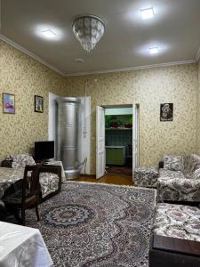 un soggiorno con divano e tavolo di 4х комнатная квартира Дом a Samarkand