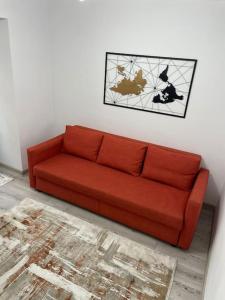 um sofá vermelho sentado numa sala de estar em Apartament D&T em Vatra Dornei