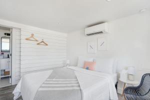 una camera bianca con un letto e una sedia blu di Breakers Montauk a Montauk