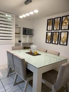 a kitchen with a white table and chairs at Casa Orquídea in Guadalajara