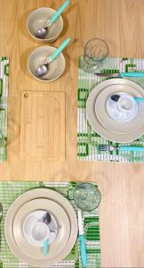a table with plates and spoons on top of it at Apartamento a 100 m da praia in Juquei