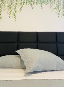 a bed with a black headboard and a white pillow at Apartamento a 100 m da praia in Juquei