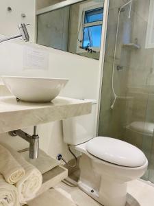 a bathroom with a sink and a toilet and a shower at Apartamento a 100 m da praia in Juquei