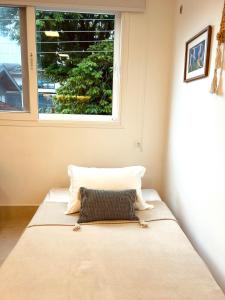 a bed in a room with a window at Apartamento a 100 m da praia in Juquei