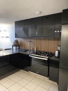 a kitchen with black cabinets and a stove top oven at Casa Orquídea in Guadalajara