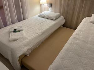 a hotel room with two beds with towels on them at Aquarius Flat Aptos e Suítes in Santa Cruz do Sul