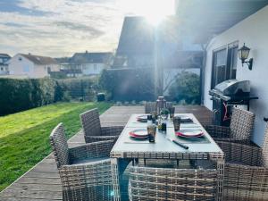 a table with chairs and a grill on a patio at idyllisches Traumhaus mit Garten in Emmelshausen