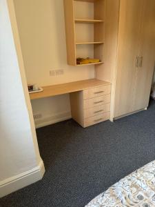 een bureau in een kamer met een kast en een bed bij Northampton town in Kingsthorpe