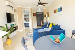 a living room with a blue couch and a table at Journey`s End with Prohomesja at Bromptons in Kingston