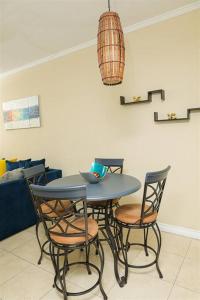 a table and chairs in a living room at Journey`s End with Prohomesja at Bromptons in Kingston