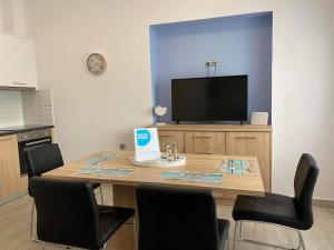 a room with a table with chairs and a tv at Magic View Apartment-Karpathos Port Pigadia in Karpathos Town