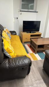 a living room with a couch and a television at Northampton town in Kingsthorpe