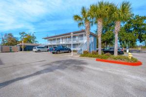 a parking lot in front of a building with palm trees at Oak Shores Studio 2 in Biloxi
