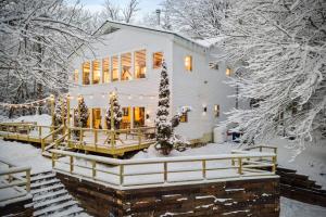 a house in the snow with snow covered trees at Maple Pine w Hot Tub Pool Table 3min to Mount Snow in Dover