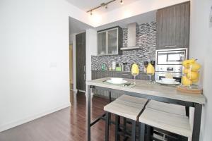 a kitchen with a table and chairs in a room at Presidential 2+1BR Condo, Entertainment District (Downtown) w/ CN Tower View, Balcony, Pool & Hot Tub in Toronto