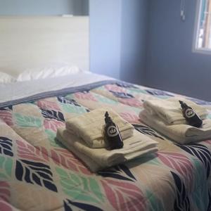 Una cama con tres toallas encima. en Tiny Home Ushuaia - Hermoso depto céntrico 1 hab en Ushuaia