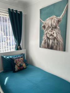 Nevis Rooms - Self check in with free onsite Parking في Inverlochy: غرفة نوم عليها لوحة بقرة على الحائط