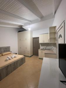 a large room with a bed and a kitchen at Eveline Rooms in Sarandë