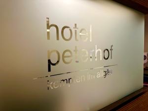 肯普滕的住宿－Hotel Peterhof - urban lifestyle Kempten，上面写着记号字的标志