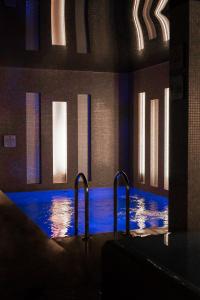 a large swimming pool with blue water in a building at Hotel Weneda in Opole