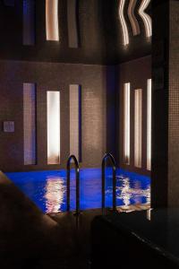 オポーレにあるHotel Wenedaの建物内の青い水の大きなプール