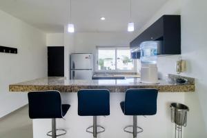 cocina con encimera con 3 sillas azules en The Restful Elephant @ Sabbia D409, en Playa del Carmen