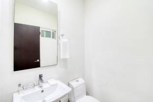 Un baño blanco con lavabo y espejo. en The Restful Elephant @ Sabbia D409, en Playa del Carmen 28 fotos más