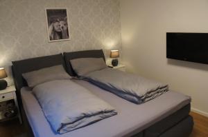 a bed with two pillows and a flat screen tv at Alpakaglück Bad Zwischenahn in Bad Zwischenahn