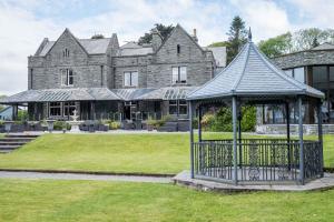an ornate gazebo in front of a mansion at Bron Eifion Hotel in Criccieth