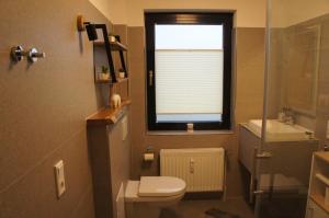 a small bathroom with a toilet and a window at Alpakaglück Bad Zwischenahn in Bad Zwischenahn
