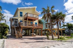 a house on the beach with palm trees at Castaway Cottage in Fort Myers Beach