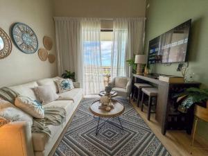 uma sala de estar com um sofá e uma televisão de ecrã plano em Paraíso Privado en Punta Cana em Punta Cana