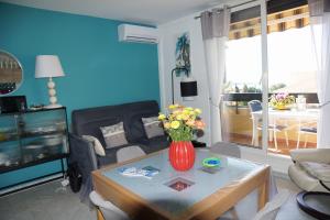 a living room with a vase of flowers on a table at Les jardins de Bandol, piscine et mer in Bandol